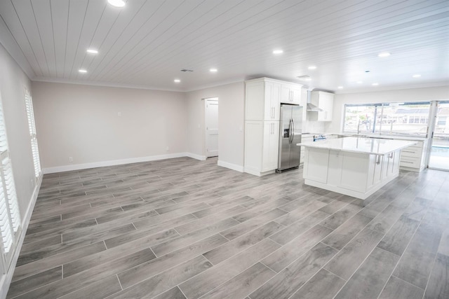 913 Spindle Palm Way, Apollo Beach, FL 33572 - kitchen with appliances with stainless steel finishes, wall chimney range hood, light countertops, crown molding, and open floor plan