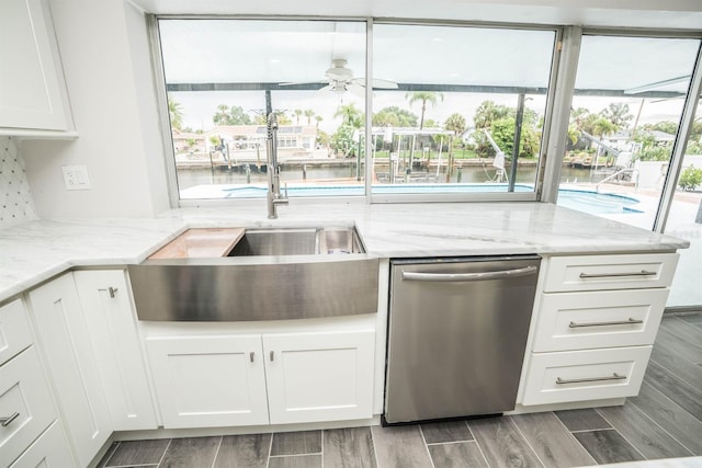 913 Spindle Palm Way, Apollo Beach, FL 33572 - kitchen featuring stainless steel dishwasher, a sink, ceiling fan, white cabinets, and light stone counters