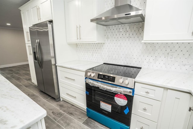 913 Spindle Palm Way, Apollo Beach, FL 33572 - kitchen with wall chimney range hood, stainless steel appliances, wood tiled floors, white cabinetry, and baseboards