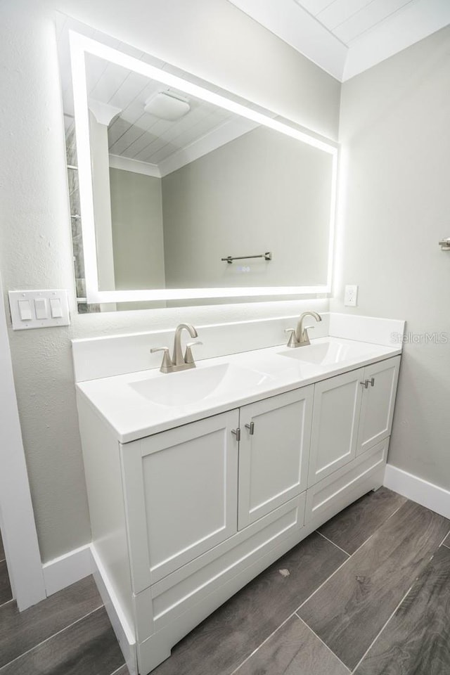 913 Spindle Palm Way, Apollo Beach, FL 33572 - full bathroom featuring double vanity, wood finished floors, baseboards, and crown molding