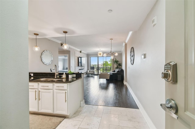1108 N Franklin St Unit 502, Tampa, FL 33602 - kitchen with a sink, dark countertops, ornamental molding, open floor plan, and white cabinetry