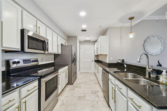1108 N Franklin St Unit 502, Tampa, FL 33602 - kitchen featuring appliances with stainless steel finishes, a sink, a peninsula, hanging light fixtures, and white cabinets
