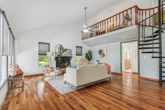 18914 Geraci Rd, Lutz, FL 33548 - living room featuring stairs, wood-type flooring, a fireplace with raised hearth, ceiling fan, and high vaulted ceiling