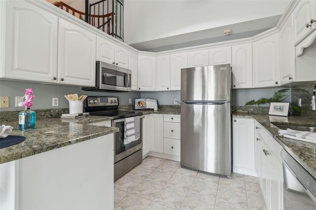 18914 Geraci Rd, Lutz, FL 33548 - kitchen with appliances with stainless steel finishes, white cabinetry, and dark stone counters