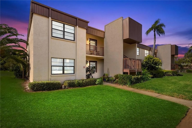 2400 Winding Creek Blvd Unit 4-101, Clearwater, FL 33761 - back of property at dusk with stucco siding and a lawn