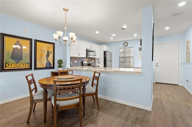 2400 Winding Creek Blvd Unit 4-101, Clearwater, FL 33761 - dining area with a chandelier, wood finished floors, and recessed lighting