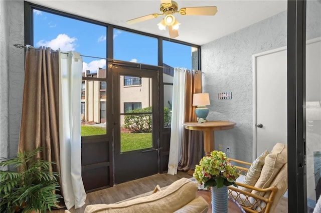 2400 Winding Creek Blvd Unit 4-101, Clearwater, FL 33761 - doorway to outside featuring a textured wall, wood finished floors, ceiling fan, and expansive windows