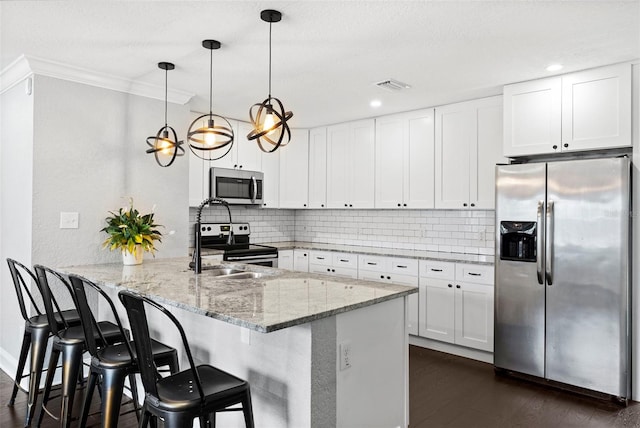 3906 W Rogers Ave, Tampa, FL 33611 - kitchen featuring appliances with stainless steel finishes, a peninsula, backsplash, light stone countertops, and white cabinetry