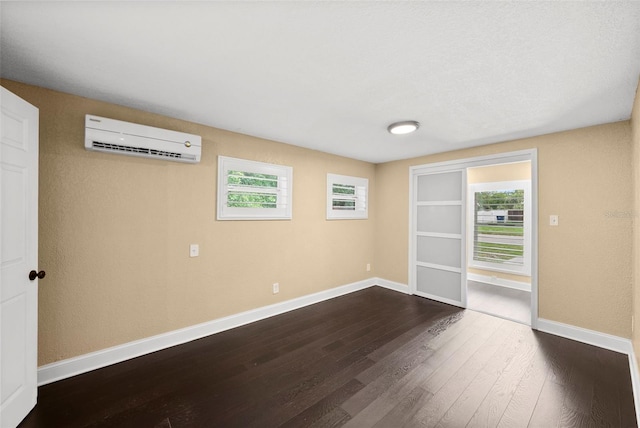 3906 W Rogers Ave, Tampa, FL 33611 - unfurnished room featuring a wall mounted AC, dark wood-type flooring, and baseboards