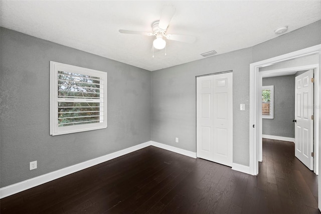 3906 W Rogers Ave, Tampa, FL 33611 - unfurnished bedroom with dark wood-style flooring, baseboards, a ceiling fan, and a closet