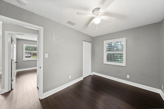 3906 W Rogers Ave, Tampa, FL 33611 - unfurnished bedroom with dark wood-style floors, a textured ceiling, a textured wall, baseboards, and a closet