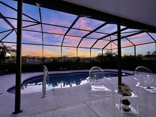 5103 98th Ave E, Parrish, FL 34219 - pool at dusk featuring an outdoor pool, glass enclosure, and a patio