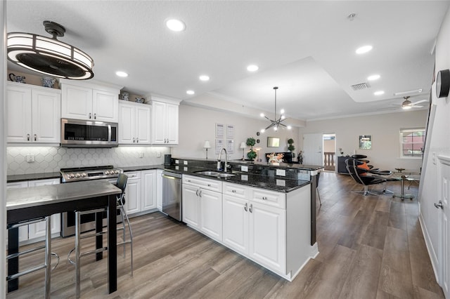 340 1st St N Unit I, Saint Petersburg, FL 33701 - kitchen featuring stainless steel appliances, a sink, a peninsula, crown molding, and backsplash