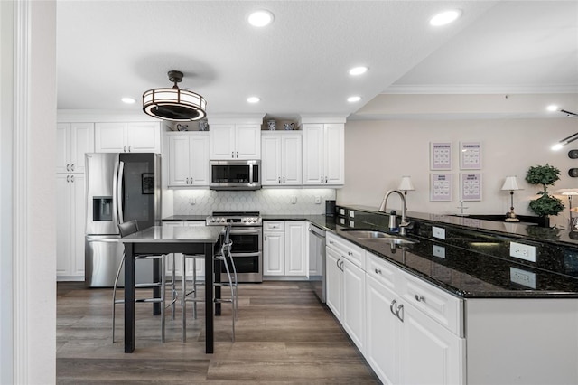 340 1st St N Unit I, Saint Petersburg, FL 33701 - kitchen with appliances with stainless steel finishes, a sink, crown molding, recessed lighting, and a peninsula