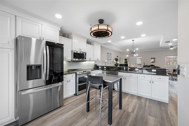 340 1st St N Unit I, Saint Petersburg, FL 33701 - kitchen featuring stainless steel appliances, a peninsula, a sink, recessed lighting, and white cabinetry
