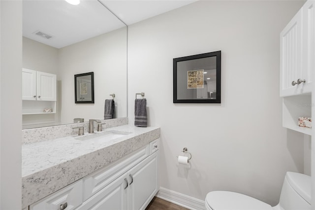 340 1st St N Unit I, Saint Petersburg, FL 33701 - bathroom with toilet, vanity, baseboards, and wood finished floors