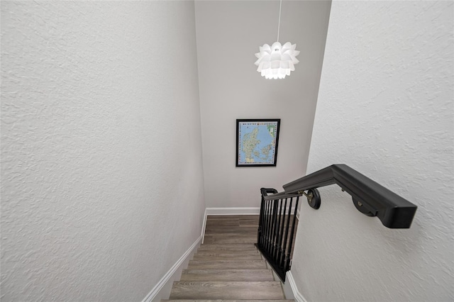 340 1st St N Unit I, Saint Petersburg, FL 33701 - staircase with wood finished floors, baseboards, a textured wall, and a chandelier