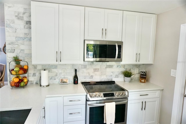 135 Emerald Ln, Largo, FL 33771 - kitchen with appliances with stainless steel finishes, decorative backsplash, light countertops, and white cabinets