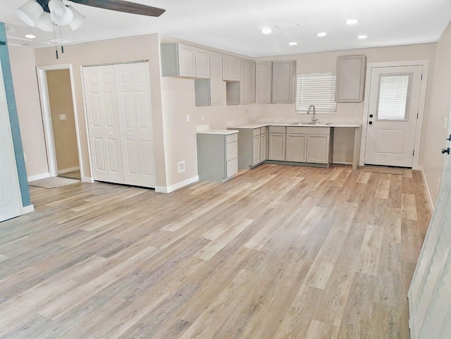 5969 NW 65th St, Ocala, FL 34482 - kitchen with gray cabinetry, a sink, ceiling fan, light wood finished floors, and baseboards