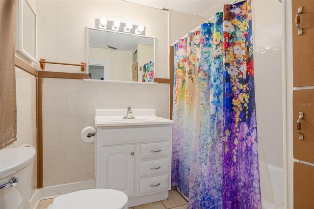 1235 Bass Blvd, Dunedin, FL 34698 - full bathroom featuring toilet, vanity, tile patterned floors, and tile walls