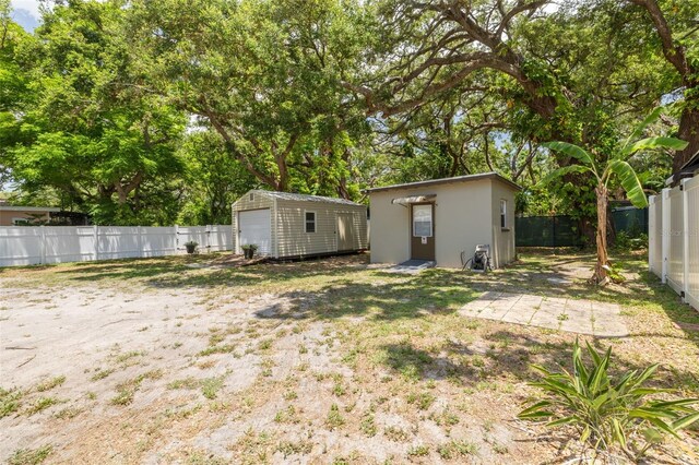 1235 Bass Blvd, Dunedin, FL 34698 - fenced backyard featuring a detached garage and view of scattered trees