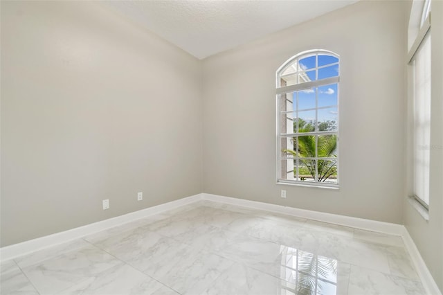 1460 Kensington Woods Dr, Lutz, FL 33549 - spare room featuring light marble finish floors, healthy amount of natural light, and a textured ceiling