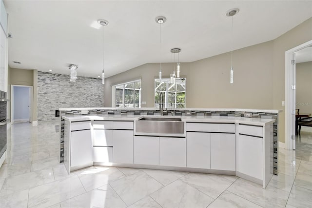 1460 Kensington Woods Dr, Lutz, FL 33549 - kitchen with white cabinets, light countertops, light marble finish flooring, and hanging light fixtures