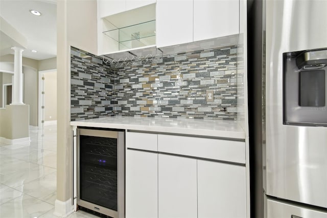 1460 Kensington Woods Dr, Lutz, FL 33549 - indoor dry bar with stainless steel fridge, beverage cooler, ornate columns, tasteful backsplash, and recessed lighting