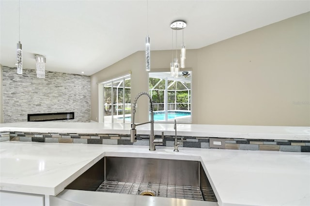 1460 Kensington Woods Dr, Lutz, FL 33549 - kitchen with a large fireplace, light stone counters, and decorative light fixtures