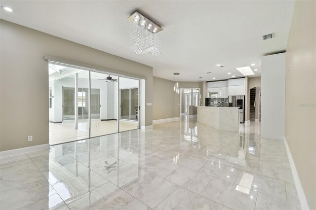 1460 Kensington Woods Dr, Lutz, FL 33549 - unfurnished room with light marble finish flooring, ceiling fan, recessed lighting, arched walkways, and plenty of natural light