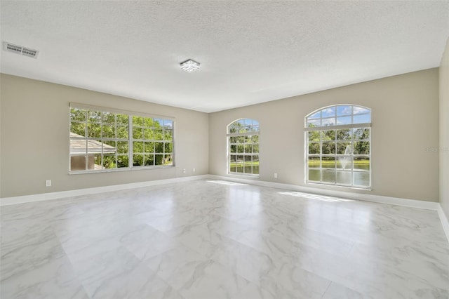 1460 Kensington Woods Dr, Lutz, FL 33549 - spare room featuring marble look tile flooring and a textured ceiling
