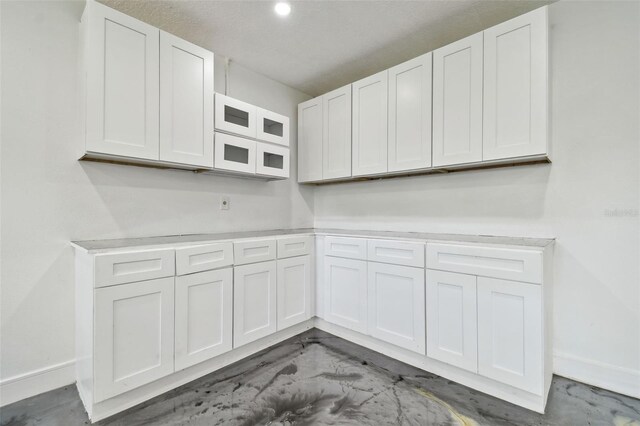 1460 Kensington Woods Dr, Lutz, FL 33549 - kitchen featuring white cabinets, light countertops, and concrete flooring