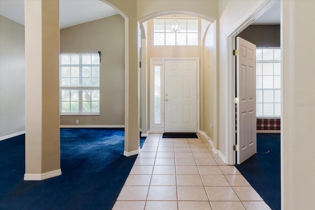 1852 Longview Ln, Tarpon Springs, FL 34689 - carpeted foyer featuring baseboards, tile patterned floors, arched walkways, and a chandelier