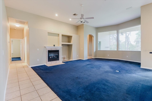 1852 Longview Ln, Tarpon Springs, FL 34689 - unfurnished living room featuring carpet, ceiling fan, tile patterned flooring, baseboards, and a tiled fireplace