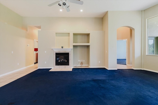 1852 Longview Ln, Tarpon Springs, FL 34689 - unfurnished living room with arched walkways, ceiling fan, a fireplace, recessed lighting, and tile patterned flooring