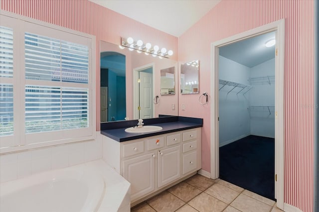 1852 Longview Ln, Tarpon Springs, FL 34689 - bathroom with vanity, a garden tub, tile patterned flooring, a walk in closet, and vaulted ceiling