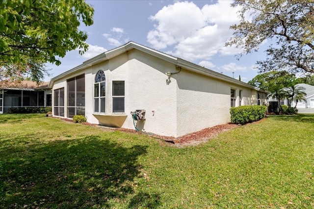 1852 Longview Ln, Tarpon Springs, FL 34689 - rear view of house featuring a sunroom, stucco siding, and a yard