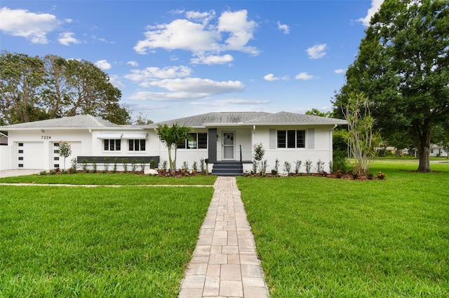 7224 Park St S, St Pete Beach, FL 33707 - view of front of property featuring stucco siding, a garage, and a front yard