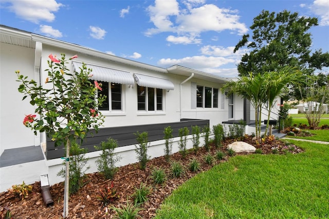 7224 Park St S, St Pete Beach, FL 33707 - view of side of home featuring a yard and stucco siding
