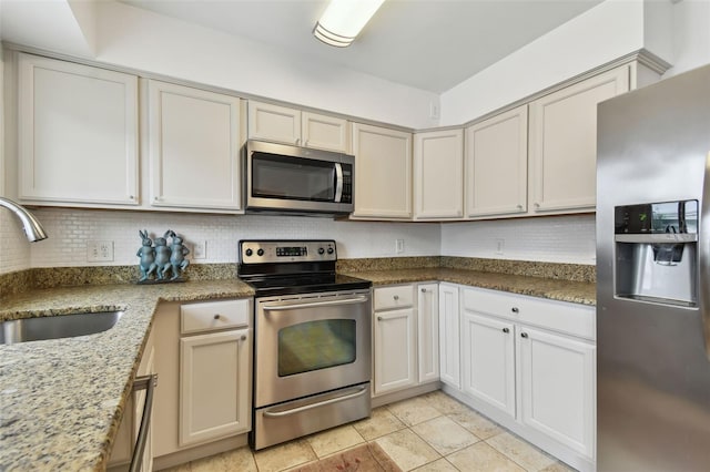 7224 Park St S, St Pete Beach, FL 33707 - kitchen featuring stainless steel appliances, a sink, backsplash, light stone countertops, and light tile patterned floors