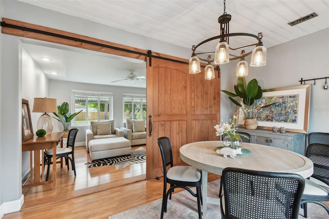 7224 Park St S, St Pete Beach, FL 33707 - dining area featuring a barn door, light wood-type flooring, and ceiling fan