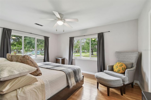 7224 Park St S, St Pete Beach, FL 33707 - bedroom with multiple windows, baseboards, light wood-style flooring, and a ceiling fan