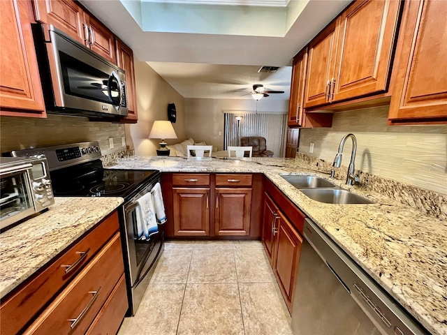 2131 Ridge Rd S Unit 76, Largo, FL 33778 - kitchen featuring appliances with stainless steel finishes, a sink, backsplash, and light stone counters