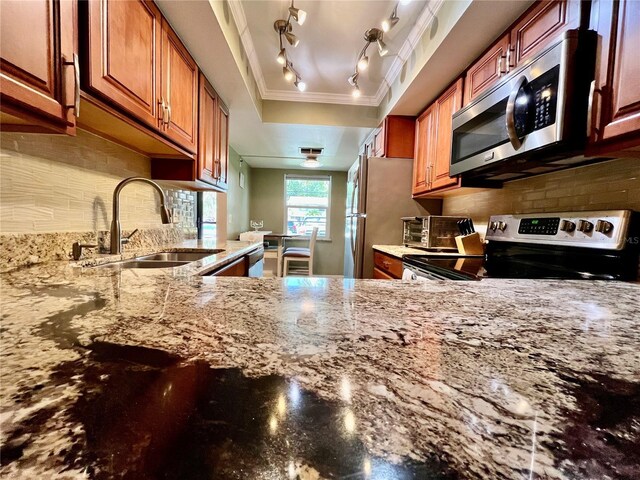 2131 Ridge Rd S Unit 76, Largo, FL 33778 - kitchen featuring appliances with stainless steel finishes, a sink, light stone counters, crown molding, and rail lighting
