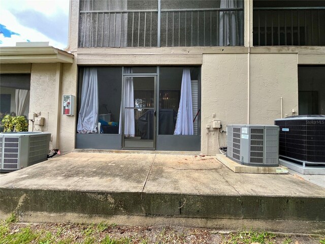 2131 Ridge Rd S Unit 76, Largo, FL 33778 - doorway to property with central AC and stucco siding