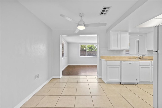 7330 Abalone Dr, Port Richey, FL 34668 - kitchen with dishwasher, light countertops, white cabinets, a ceiling fan, and light tile patterned floors