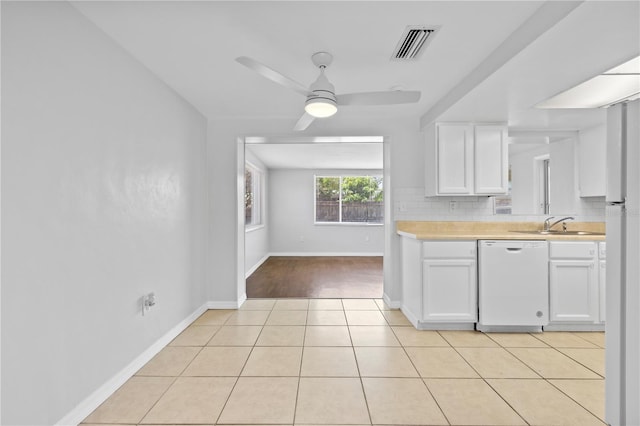 7330 Abalone Dr, Port Richey, FL 34668 - kitchen featuring white dishwasher, light countertops, white cabinetry, a ceiling fan, and light tile patterned flooring