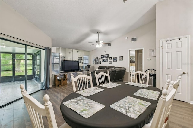 13127 Topflite Ct, Hudson, FL 34669 - dining space featuring lofted ceiling, ceiling fan, wood finished floors, and a textured ceiling
