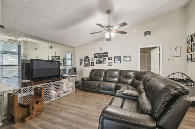 13127 Topflite Ct, Hudson, FL 34669 - living area with vaulted ceiling, a ceiling fan, plenty of natural light, wood finished floors, and a textured ceiling