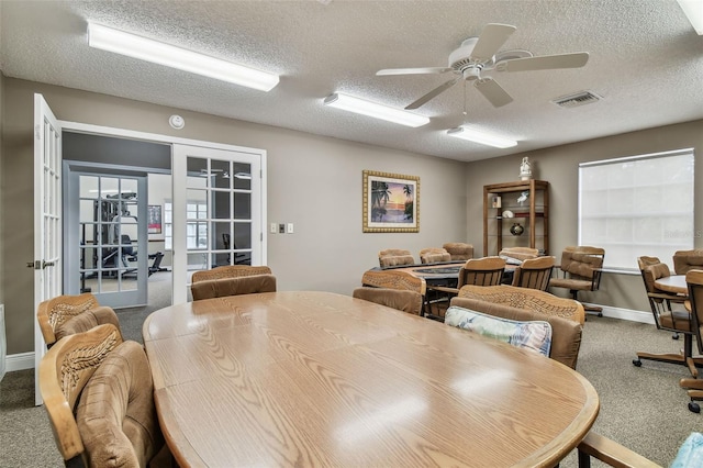13127 Topflite Ct, Hudson, FL 34669 - carpeted dining area featuring a ceiling fan, a textured ceiling, french doors, and baseboards